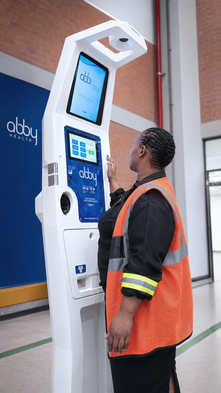 A worker in hi vis at an Abby Health Station